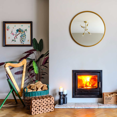 Living room with a fireplace, harp, and decorative items.