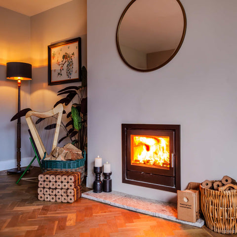 Wood-burning stove in a room with a harp, basket, and candles.